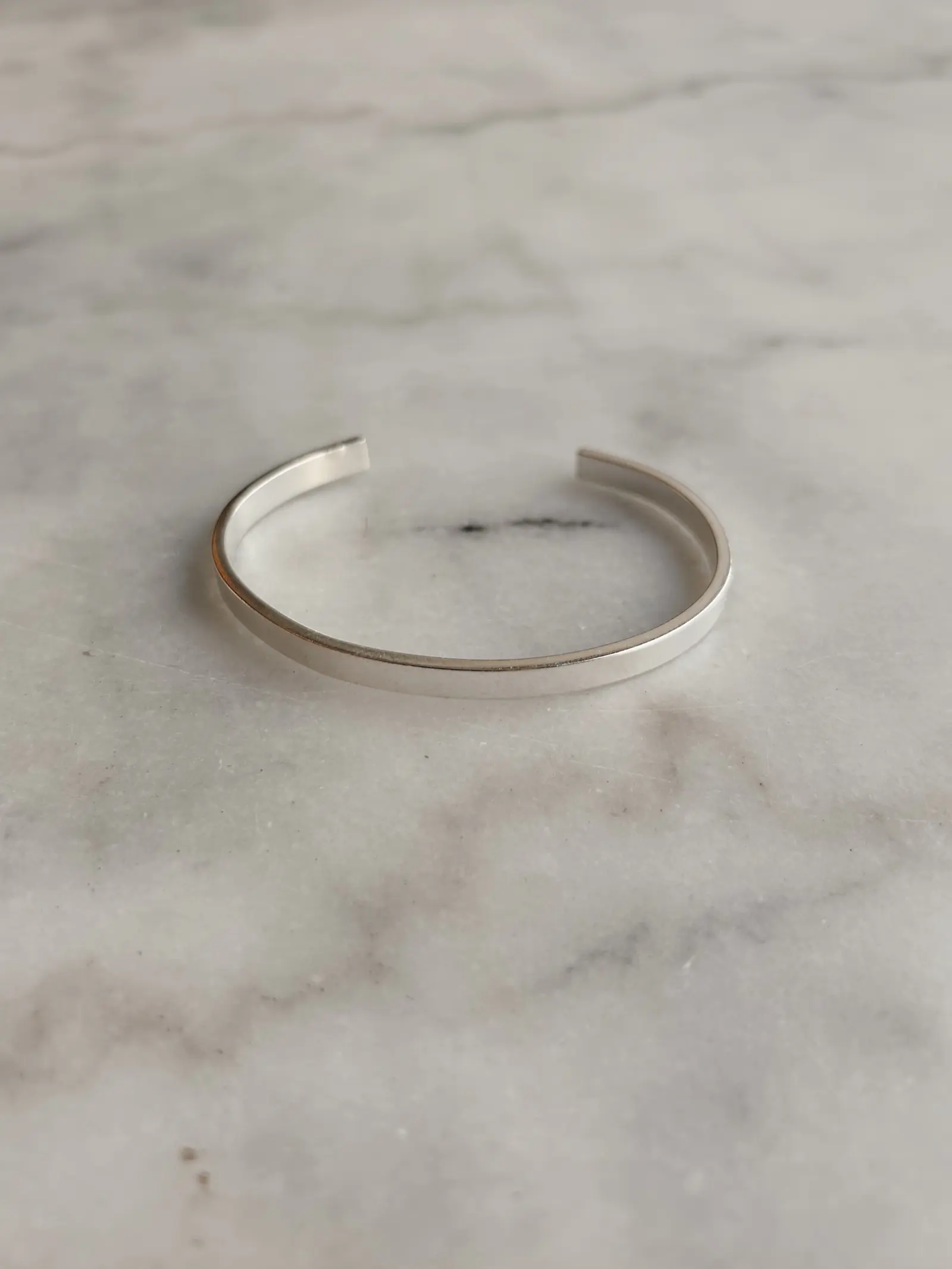 The Refined Arm cuff på vit marmor, öppningen vänd uppåt