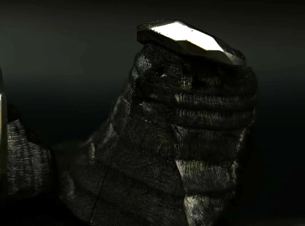 Den diamantformade cuffen på mörk sten, ljuset fångat i facetterna