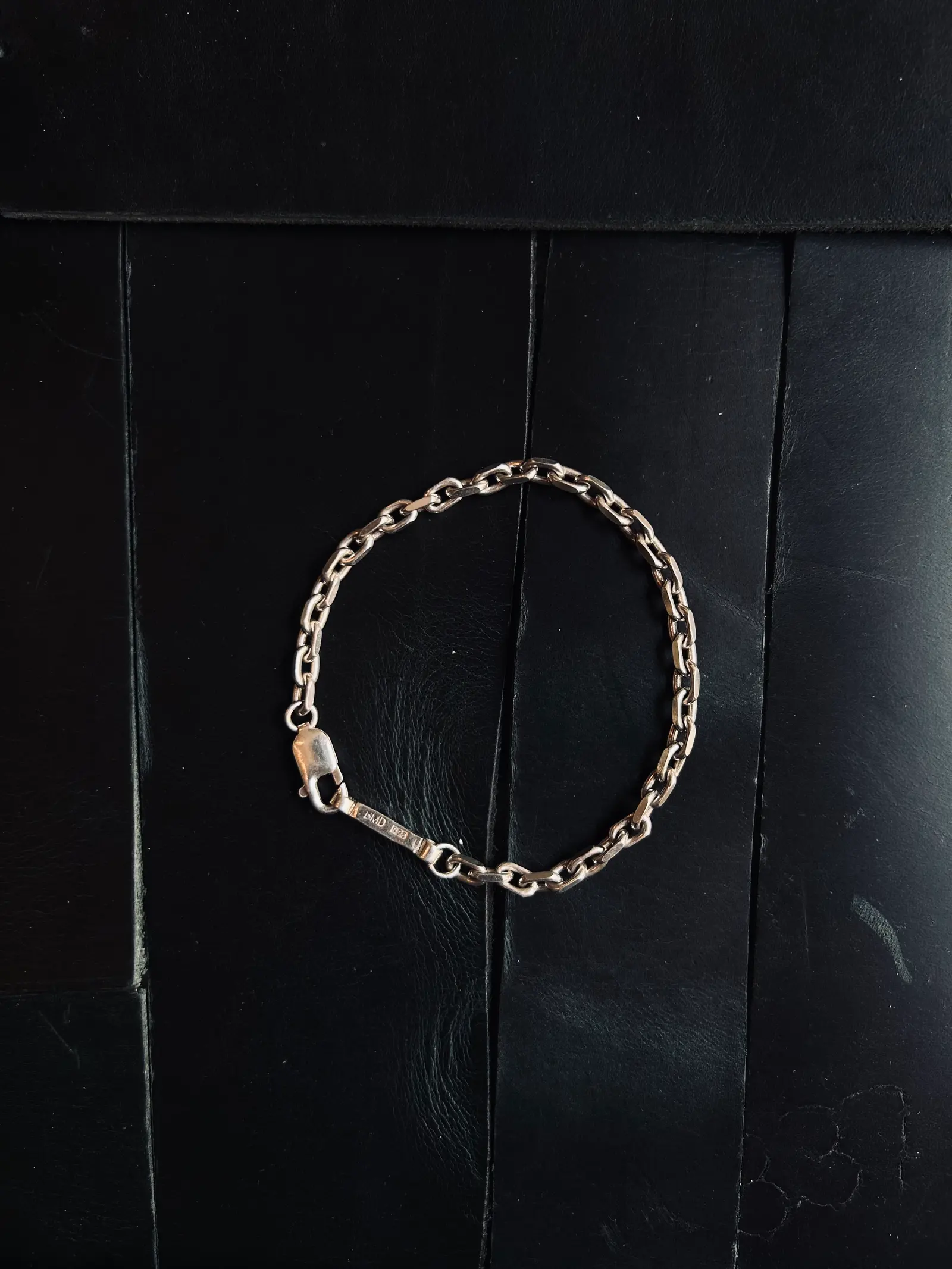 The Bulky Bracelet i samma grova länk, utlagt på svart trä