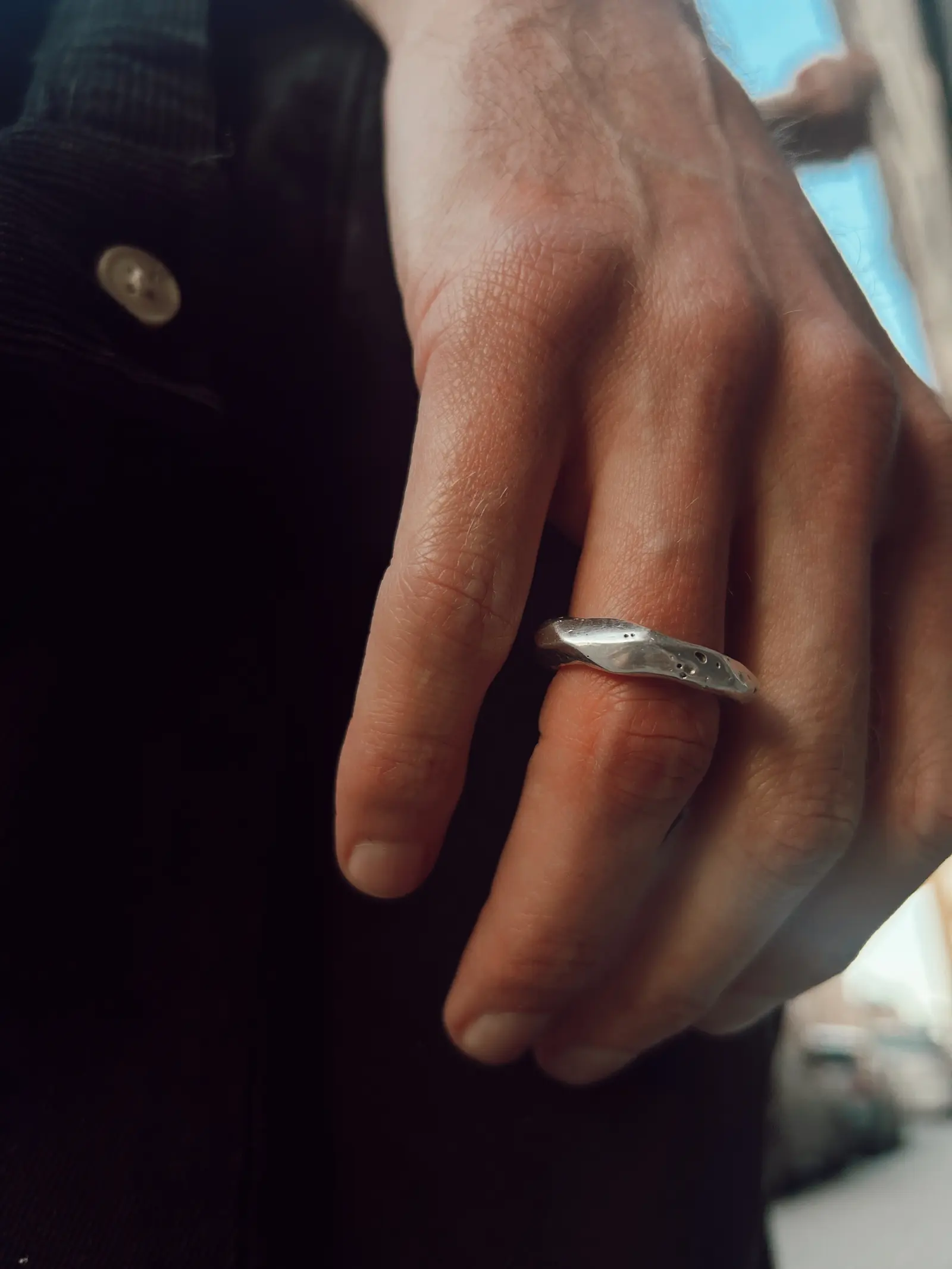 No.3 buren på ett pekfinger mot mörka kläder
