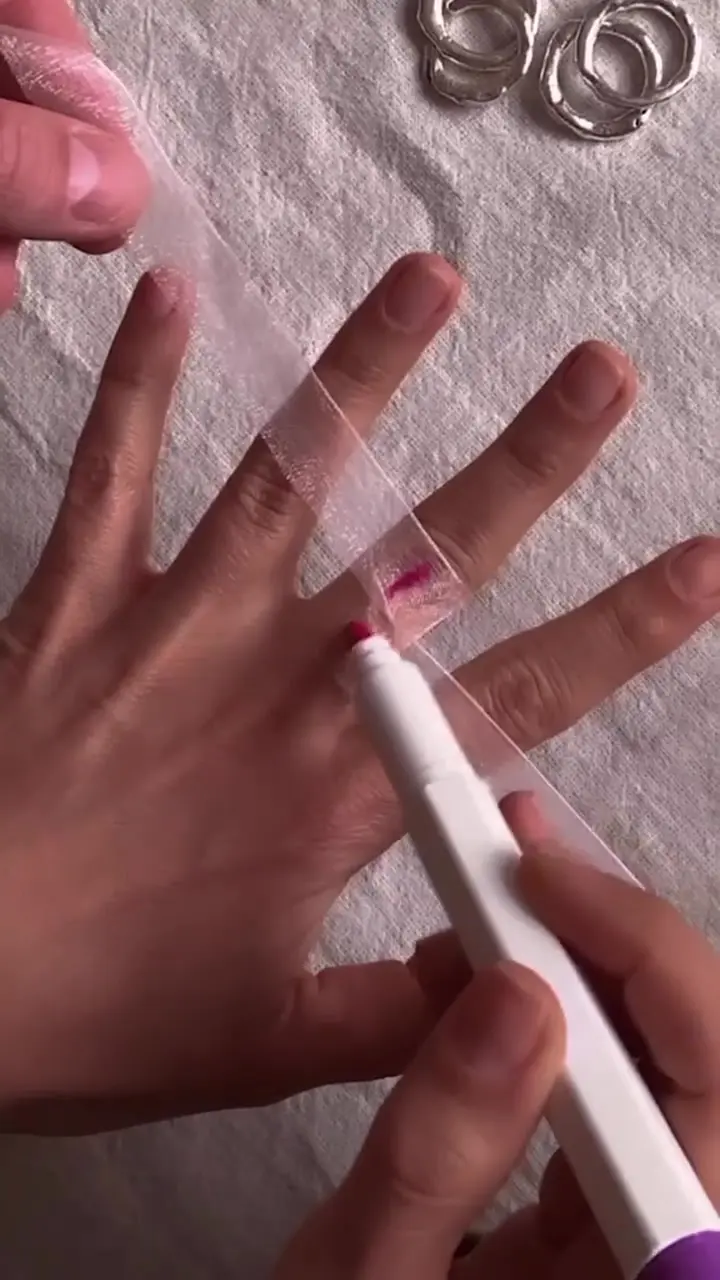 Ringmåttsguide: en pappersremsa markeras runt ett finger