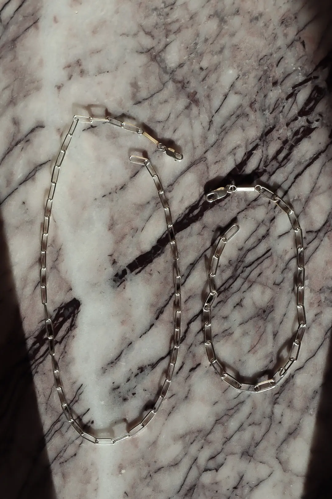 Halsband och armband ur The Given utlagda på marmor