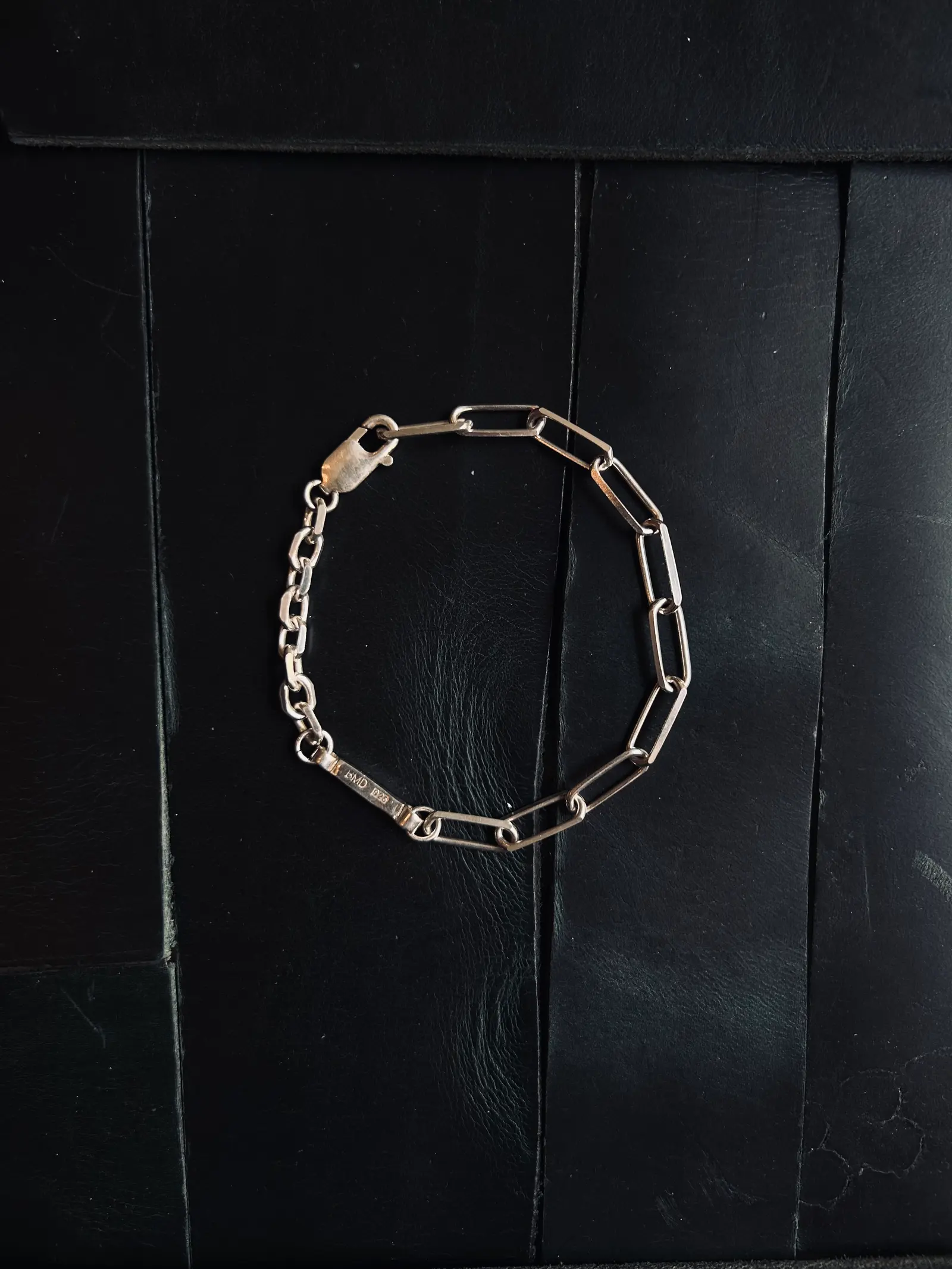 The Mood Bracelet på svart trä, de två länkbredderna syns tydligt