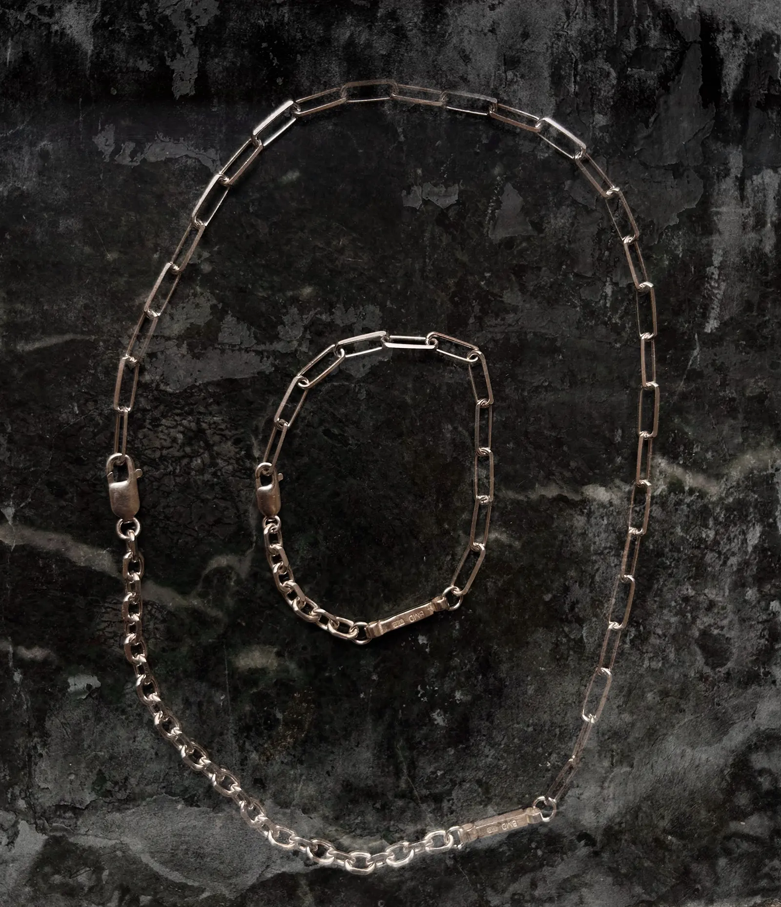 Halsband och armband ur Mood-serien utlagda på mörk sten