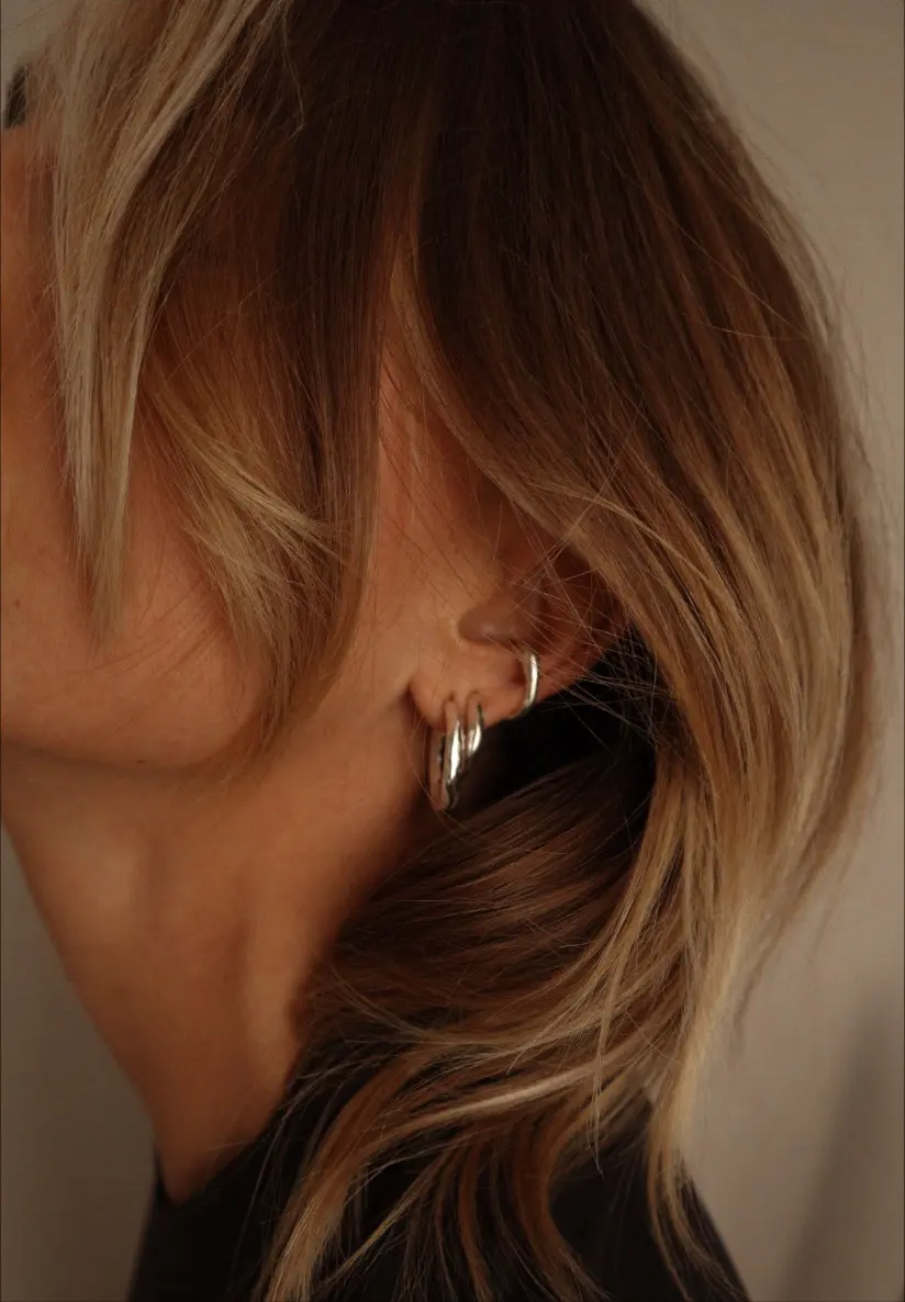 Fyra hoops och cuffs utlagda i snedställt ljus mot beige botten
