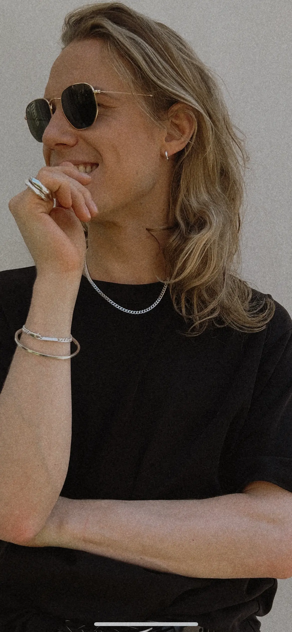 Arm cuff och ringar burna till svart t-shirt och halskedja